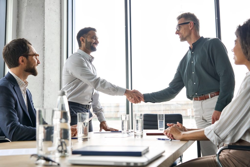 two professionals shaking hands in a business setting