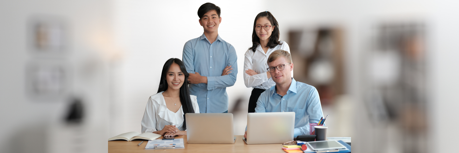 Equipo de profesionales trabajando con ordenadores portátiles en un entorno de oficina moderno y colaborativo.